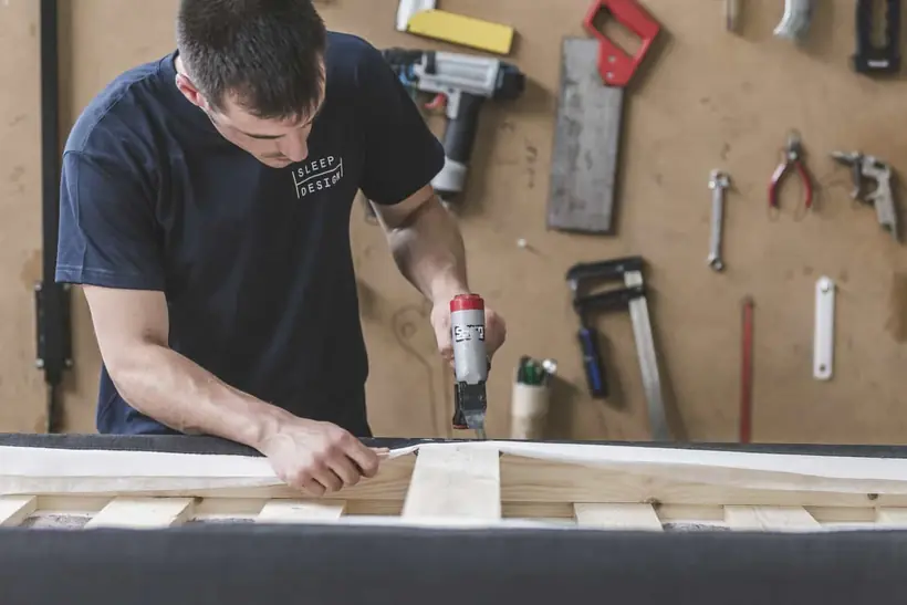 Ateliermedewerker van Sleep Design bouwt een boxspring op