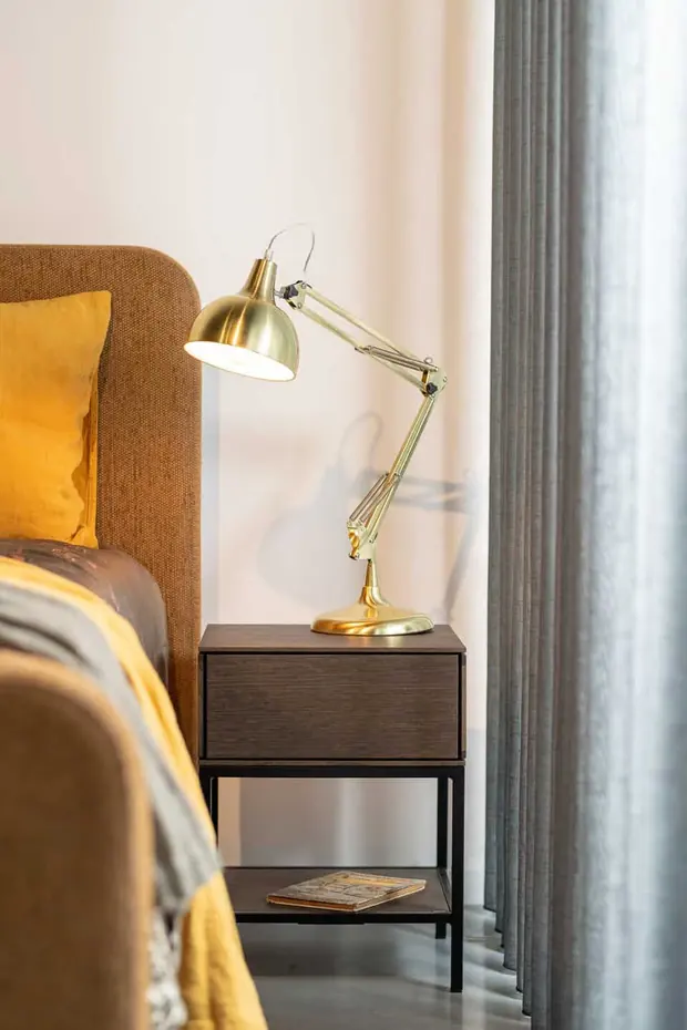 Okergele bekleding, een messing leeslamp en een bijpassend nachtkastje in een slaapkamer van Sleep Design